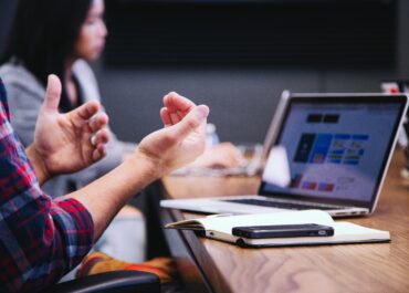 Laptop on a desk and human hands